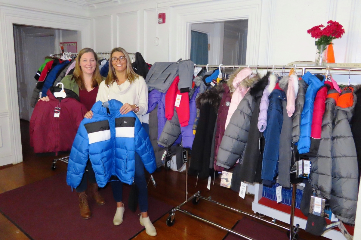 United Way Family Center Staff, Lauren Connors and Alison Lopes, pose with 75 coats prior to distribution