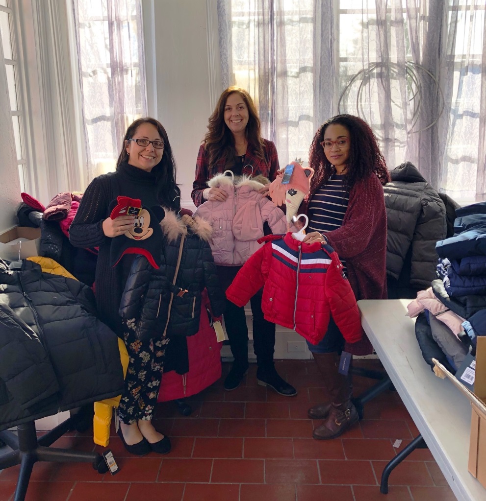 United Way Family Center Staff pose with some of the coats prior to distribution